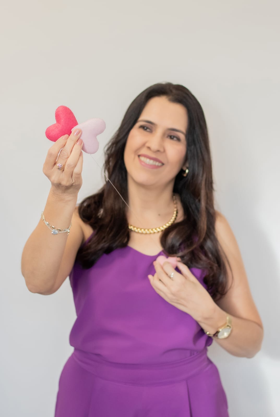 Lucy Cunha segurando corações, símbolo de conexão